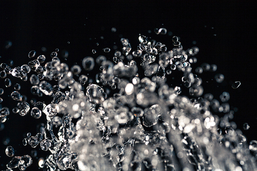 Water drops levitation on black background and do it against law of physics, copyspace