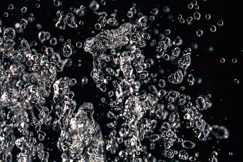 Many water drops frozen in an air on dark background, water concept