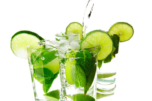 Making mojito cocktails with lime and mint isolated on white