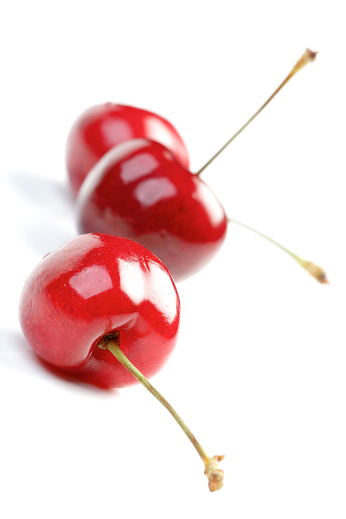 Three cherries on white backround