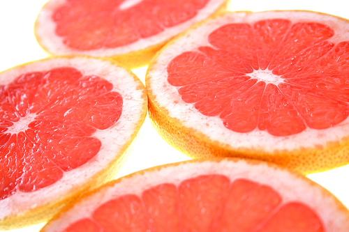 Closeup of sliced grapefruit on white background