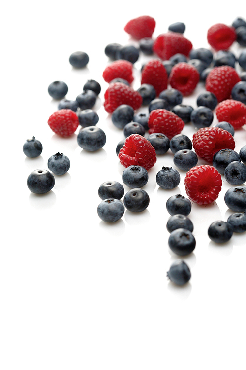 Raspberries and blueberries on white background