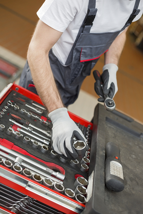 High angle view of male mechanic arranging tools in drawer at car repair shop