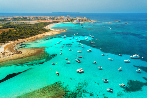 Boats and luxury yachts in transparent sea at sunset in summer in Mallorca, Spain. Aerial view. Colorful seascape with bay, azure water, sandy beach, blue sky. Balearic islands. Top view. Travel