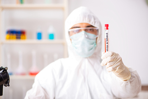 Young handsome lab assistant testing blood samples in hospital