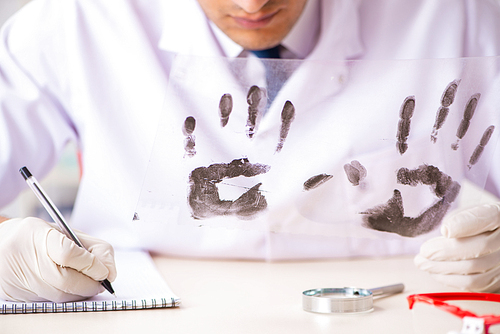 Forensic expert studying fingerprints in the lab