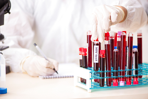 Young handsome lab assistant testing blood samples in hospital