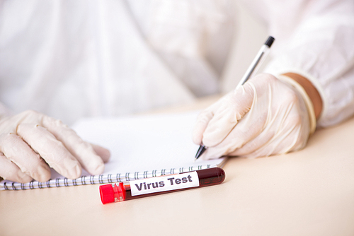 Young handsome lab assistant testing blood samples in hospital