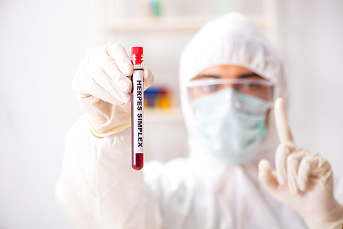 Young handsome lab assistant testing blood samples in hospital