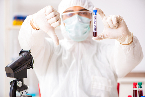 Young handsome lab assistant testing blood samples in hospital