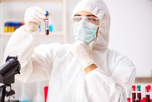 Young handsome lab assistant testing blood samples in hospital