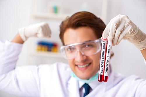 Young handsome lab assistant testing blood samples in hospital