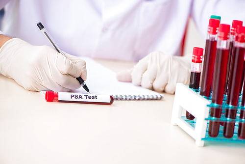 Young handsome lab assistant testing blood samples in hospital