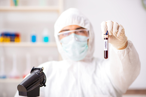 Young handsome lab assistant testing blood samples in hospital