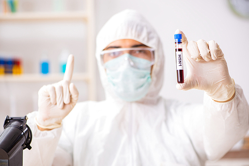 Young handsome lab assistant testing blood samples in hospital