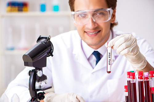 Young handsome lab assistant testing blood samples in hospital