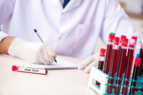 Young handsome lab assistant testing blood samples in hospital