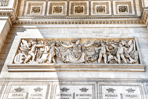 Details of Arc de Triomphe on blue sky in Paris France