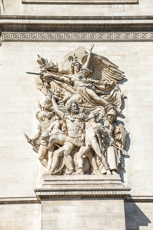 Details of Arc de Triomphe on blue sky in Paris France