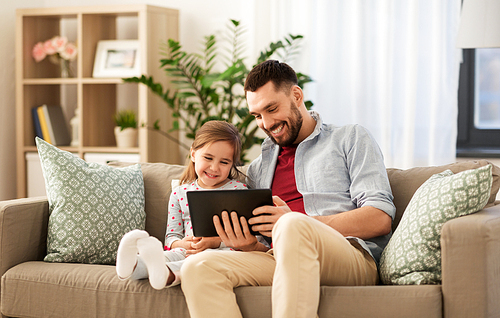 family, fatherhood and technology concept - happy father and little daughter with tablet pc computer at home