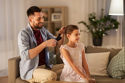 family and people concept - happy father brushing daughter hair at home