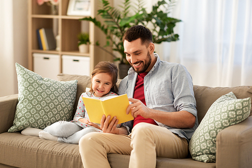family, leisure and people concept - happy father and daughter reading book at home