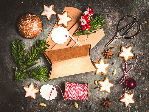 Christmas gifts wrapping . Flat lay with Cardboard boxes, cookies , fir twigs and scissors on dark wooden background, top view