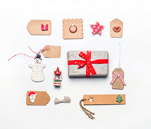 Christmas gift wrapping concept. Flat lay of various craft eco paper cardboard package and tags with vintage decoration on white desktop background, top view.