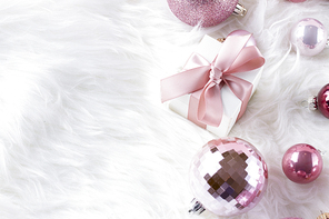 Pink Christmas decorations on white fur background with copy space