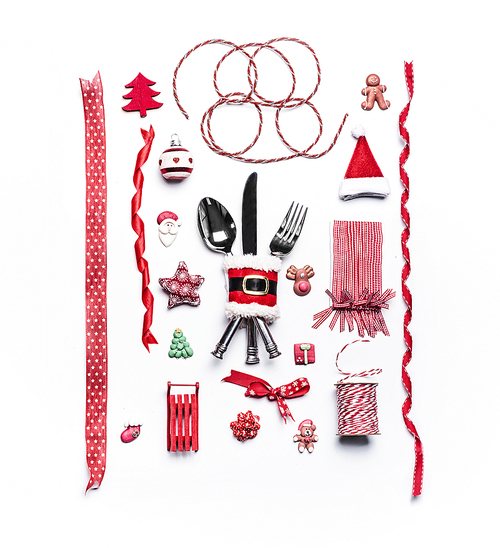Christmas concept. Various festive holiday objects: gift ribbons,Santa ,balls, table place setting with cutlery,  Christmas tree, decorations, star, ginger man on white background. Flat lay, top view
