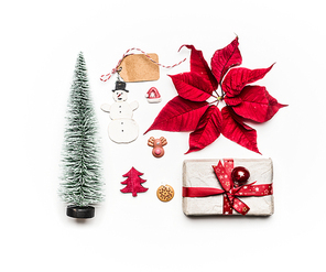 Christmas concept. Various holiday objects: gift, Christmas tree, decorations, red poinsettia, snowman, tags on white background. Flat lay, top view