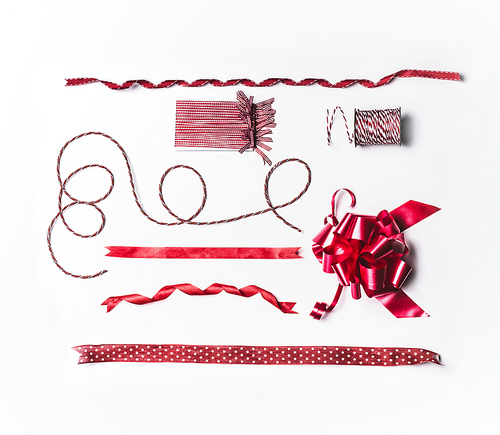 Various Christmas ribbons and bows for decoration and gift wrapping and  packaging on white background, top view, flat lay