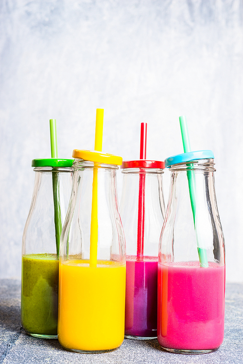 Vitamin smoothie in bottles with straws on light background.  Superfoods and healthy lifestyle or detox  diet food concept.