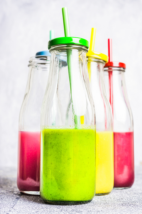 Various of smoothie and drinks  in bottle with straws  on light wooden background, side view. Healthy lifestyle and detox or diet  food concept