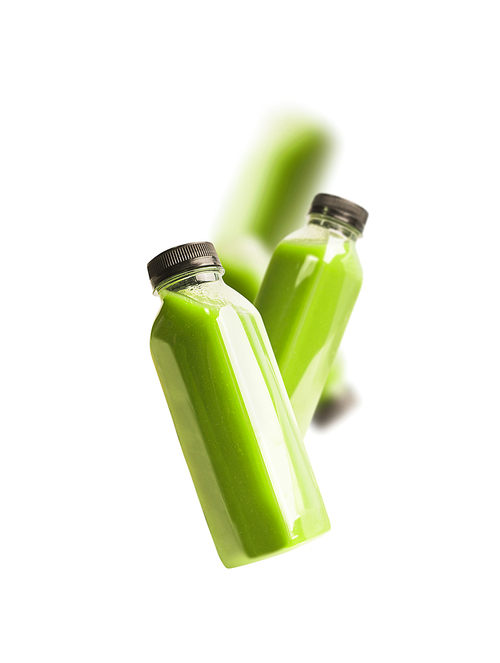 Flying green smoothie or juice bottles , isolated on white. Branding copy space