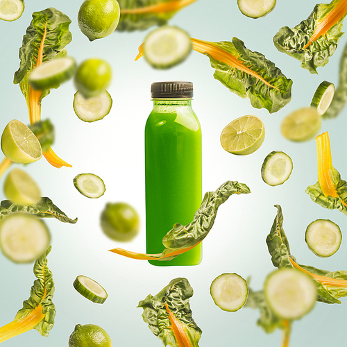 Green smoothie bottle with flying or falling ingredients: citrus fruits, cucumber and chard leaves on light blue background. Healthy detox beverages. Detox, dieting, clean eating