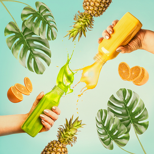 Summer beverages concept. Female hands holding bottles with splash smoothie or juice on blue background with tropical leaves and fruits