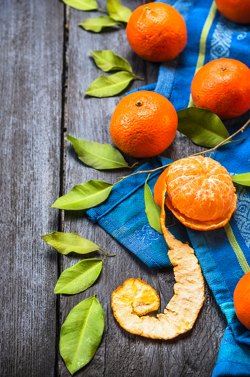 Tangerines  with  leaves on blue wooden background with towel