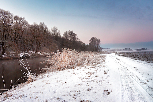 Winter misty dawn on the river. Rural foggy and frosty scene in Belarus