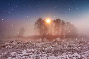 Magic winter Christmas night. Snowfall scene on a river. Frost and snowflakes under the moonlight