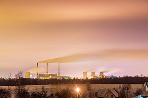 Thermal power plant and cooling towers at night near the city