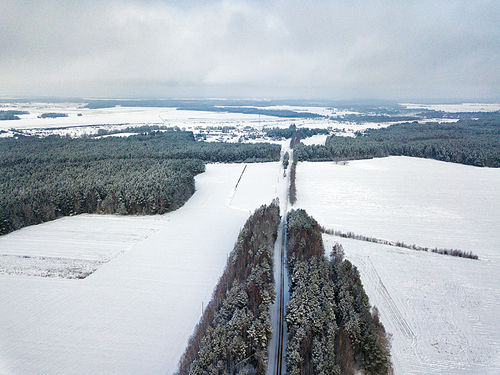 Winter countryside aerial view. landscape with fields, woodland, forest, meadow and village. Photography from a drone.