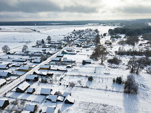 Winter rural landscape. Village, houses coverd by snow. Aerial view over private houses in wintertime