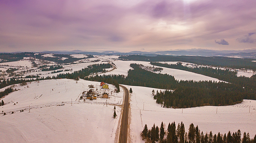 winter snowy mountain landscape.  cloudy sky. aerial rural view of road passing to horizon. carpathian mountains, beskids range