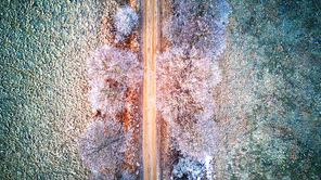 Rural misty dawn morning landscape. Aerial view of frozen road in early spring. Beautiful sunrise in Belarus.