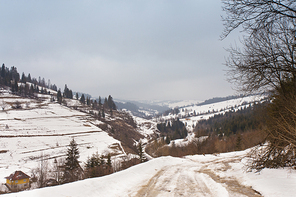 Snowy ground in winter Carpathian mountains. Extreme path rural dirt road on the hills