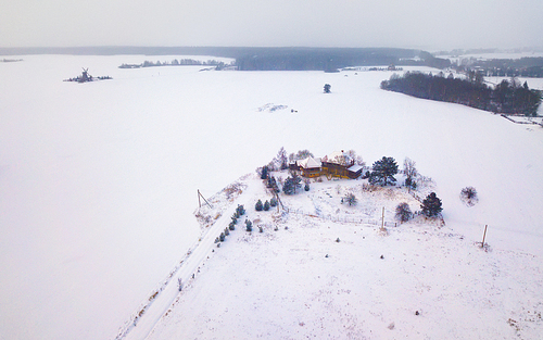 Aerial view of authentic wooden windmill and country house at winter season. Aerial view of landmark Dudutki in Belarus