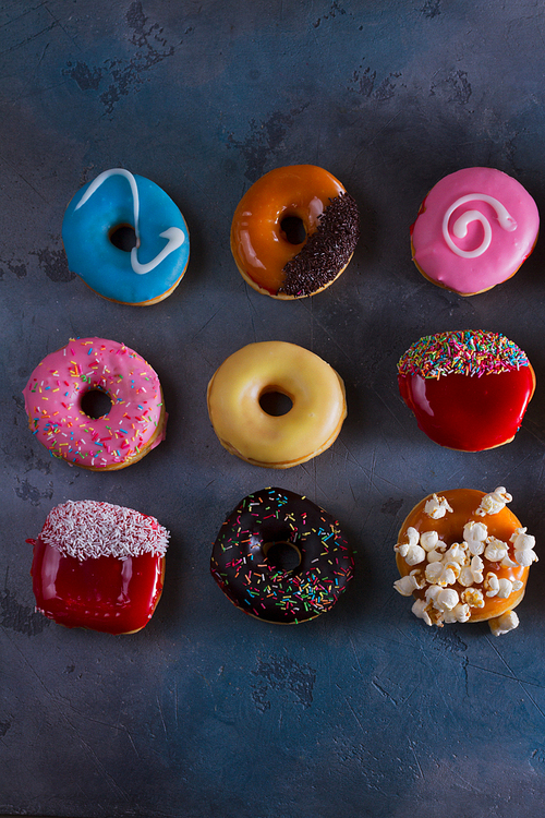 sweet doughnuts on gray stone background, top view