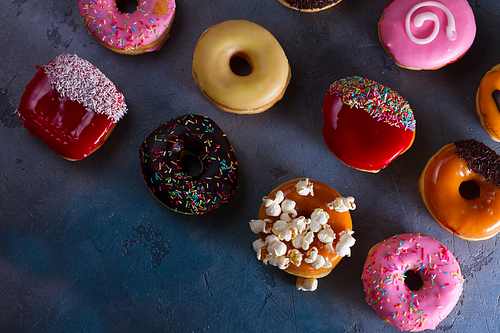 sweet doughnuts putters on gray stone background, flat lay scene