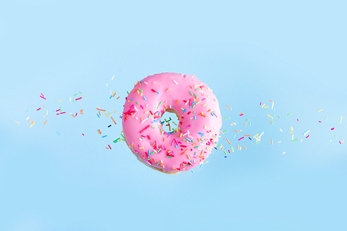 one pink flying sweet doughnut with sprincles on blue